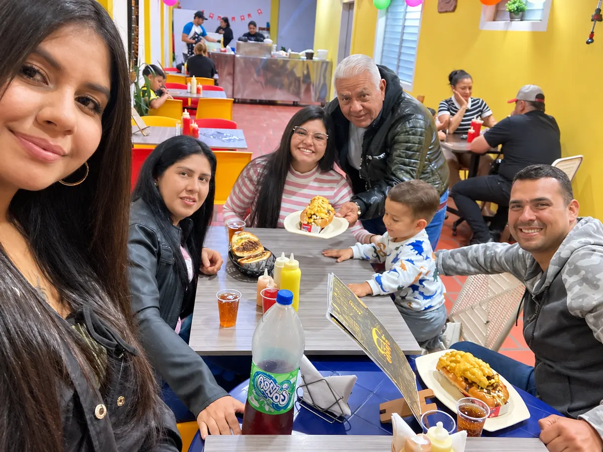 Familia compartiendo hamburguesas y perros calientes en el salón de Flakko Burguer